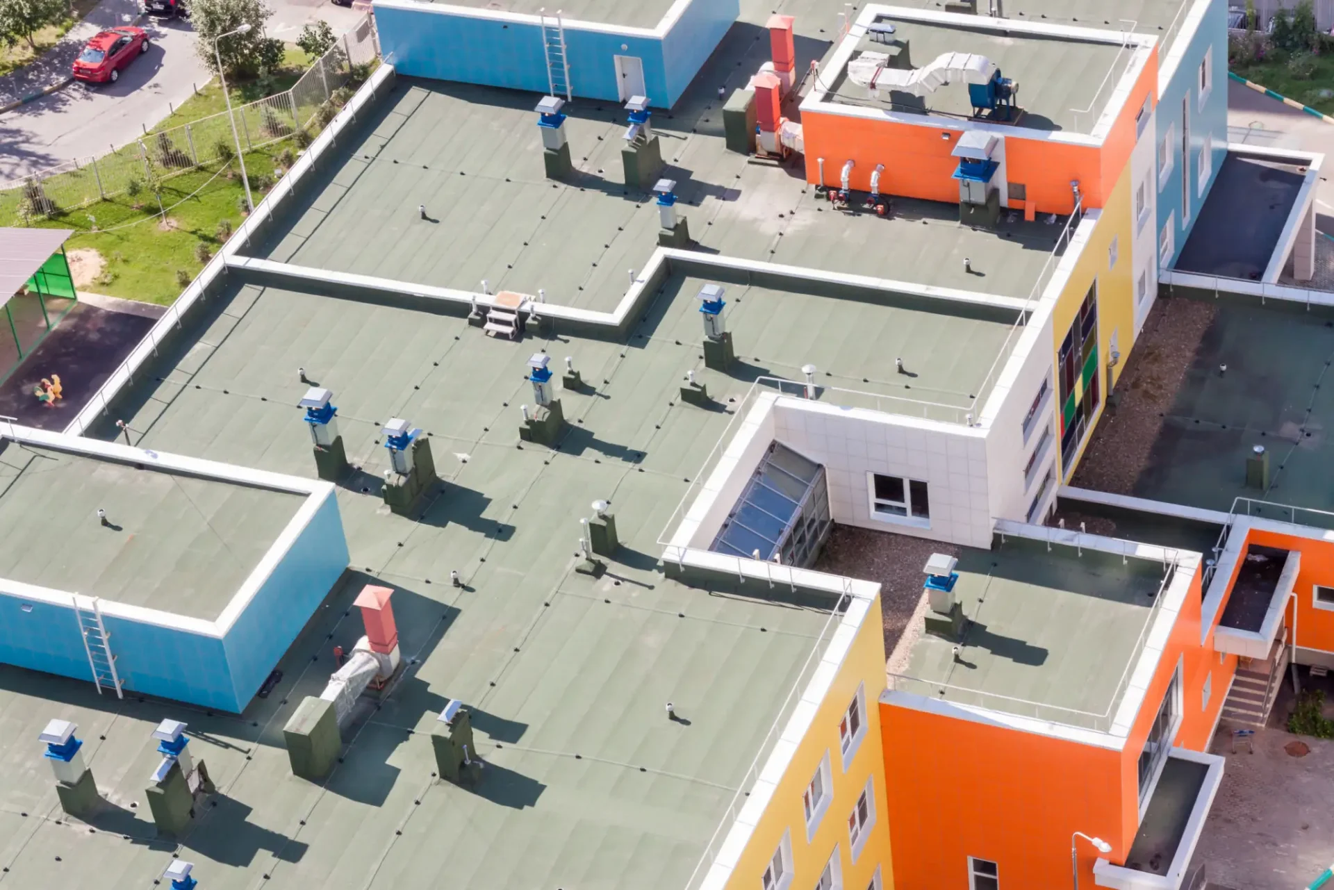 Aerial view of colorful buildings with flat roofs and ventilation units.